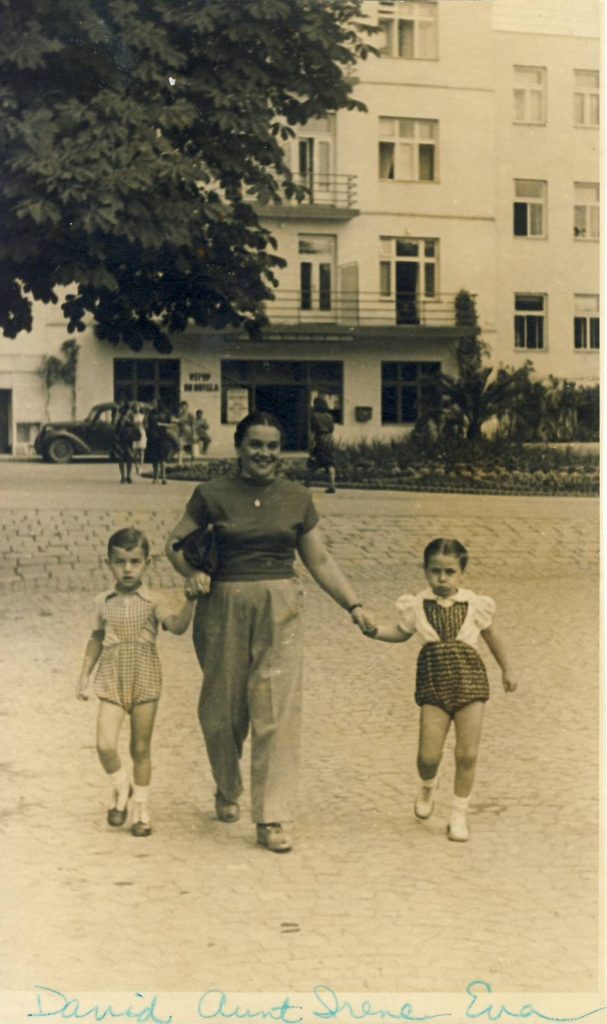 Young Eva with her aunt and cousin walking down the street